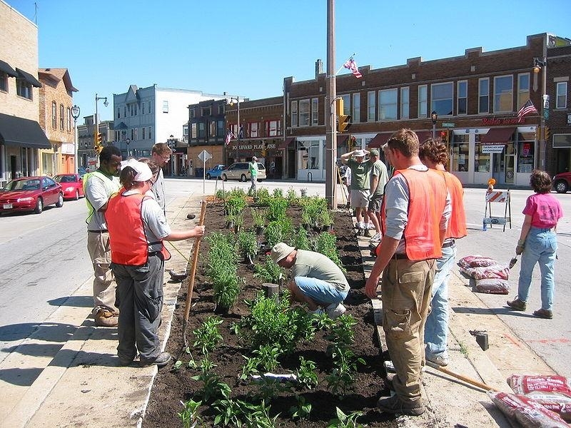 A community group of ten people are planting an urban garden in the town center. Research on climate change communication strategies suggests images of climate solutions with real people are more compelling.